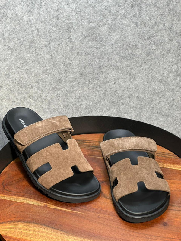 Hermès Chypre sandals brown suede upper with a black rubber sole.